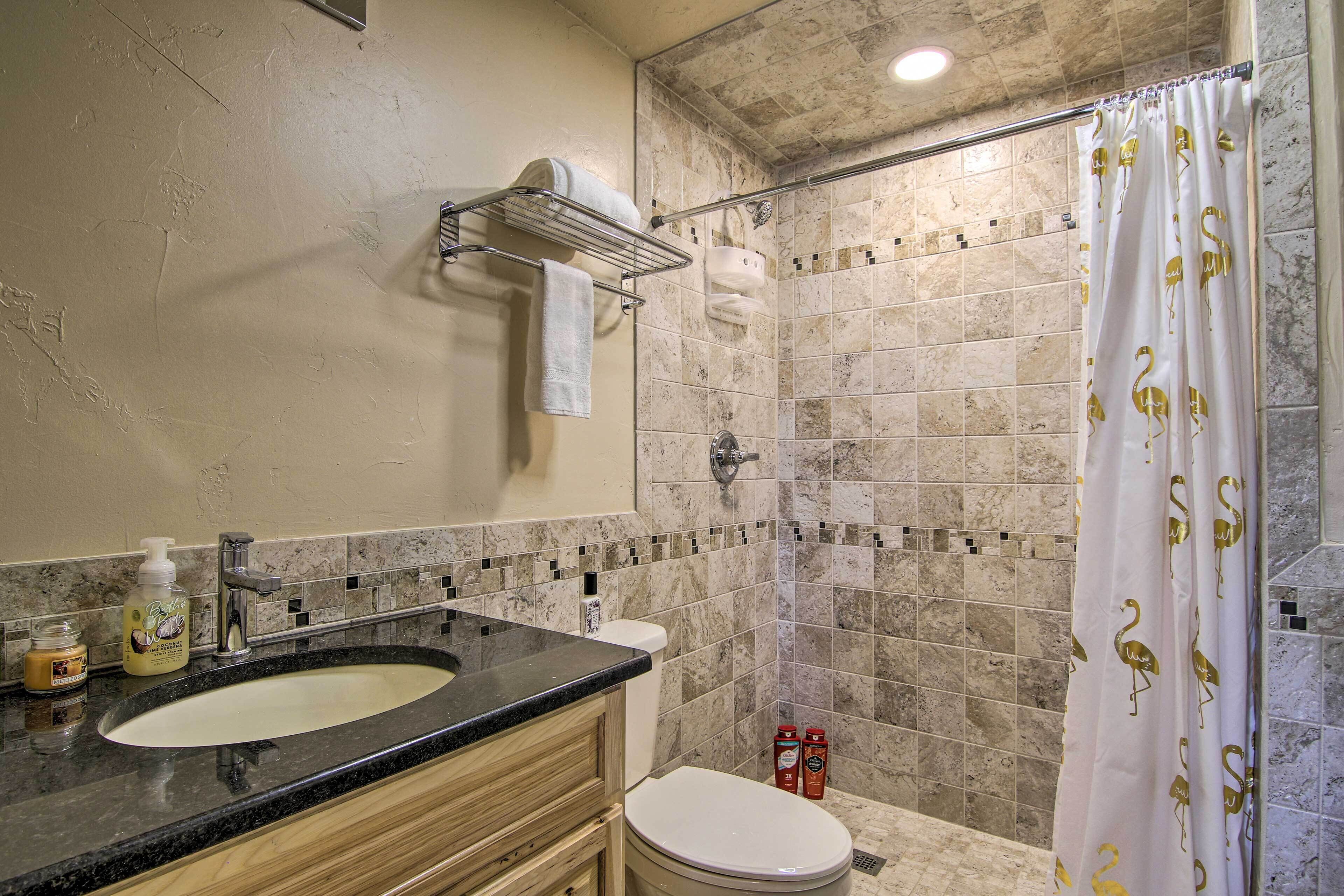 A bathroom with a sink, toilet, and shower.