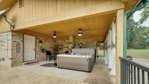 A covered outdoor area with a hot tub, wooden ceiling, and brick walls. - Updated Family Home, 20 Mi to Broken Bow Lake! (Bethel)