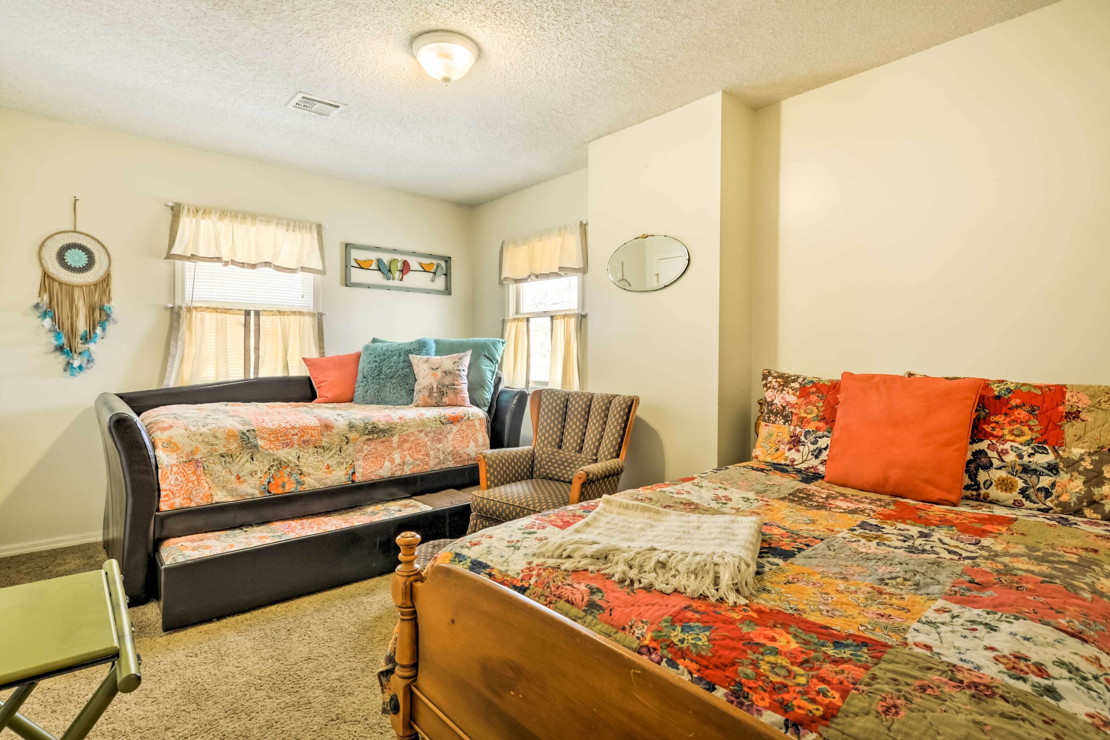 A bedroom with a bed, a sofa, a chair, and a small table.