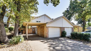 A residential house with a garage, covered porch, and a brick entrance. - 4 Mi to At&t Stadium: Fort Worth Townhome! (Fort Worth)