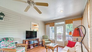 A living room with a television, sofa, armchair, and coffee table. - Home in The Villages w/ Lanai & Private Hot Tub! (The Villages)