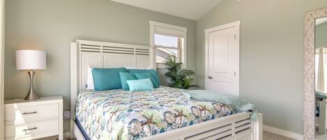 Un dormitorio con cama, mesita de noche, lámpara, ventana y espejo.