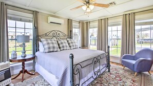 A bedroom with a bed, a chair, a table, and a ceiling fan. - Pet-friendly Surfside Beach Home w/ Deck & Grill (Freeport)