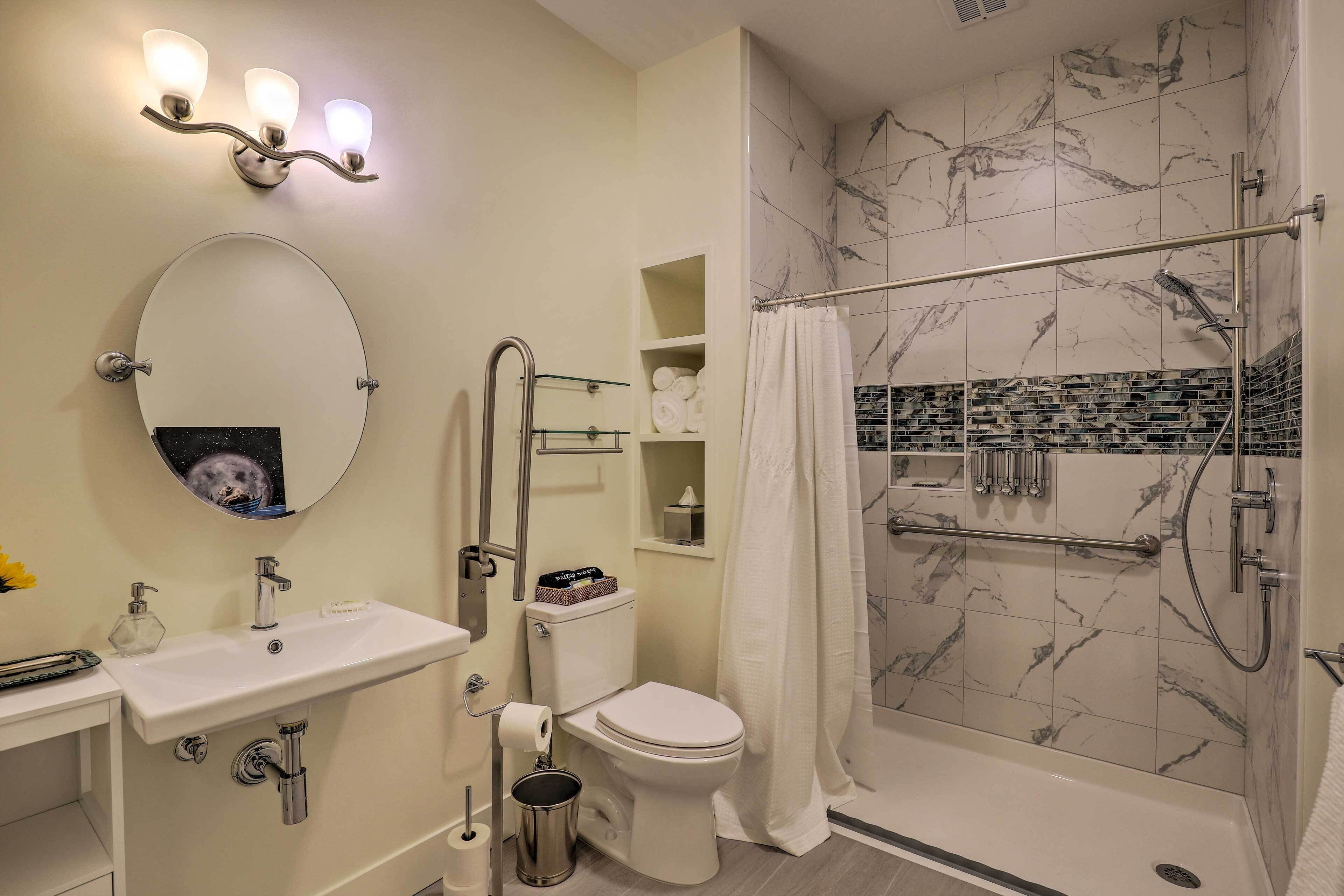 Un baño moderno con inodoro, lavamanos y ducha.