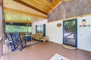 A covered porch with wooden flooring, wicker furniture, and a glass door leading to a deck. - 9 Mi to Sugar Mountain! Family Cabin w/ Fire Pit (Newland)