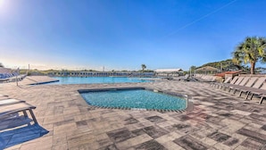 Une piscine avec des chaises longues et un palmier.