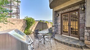 Eine Terrasse im Freien mit Grill, Tisch und Stühlen sowie einer Steinwand.