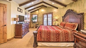 Ein Schlafzimmer mit einem großen Bett, einem Holzkopfende und einem eingebauten Schreibtisch mit Stuhl.