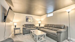 A living room with a sectional sofa, a coffee table, a lamp, and a painting on the wall.
