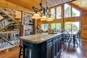 Un interior espacioso de madera con un amplio comedor, una isla de cocina y una escalera.
