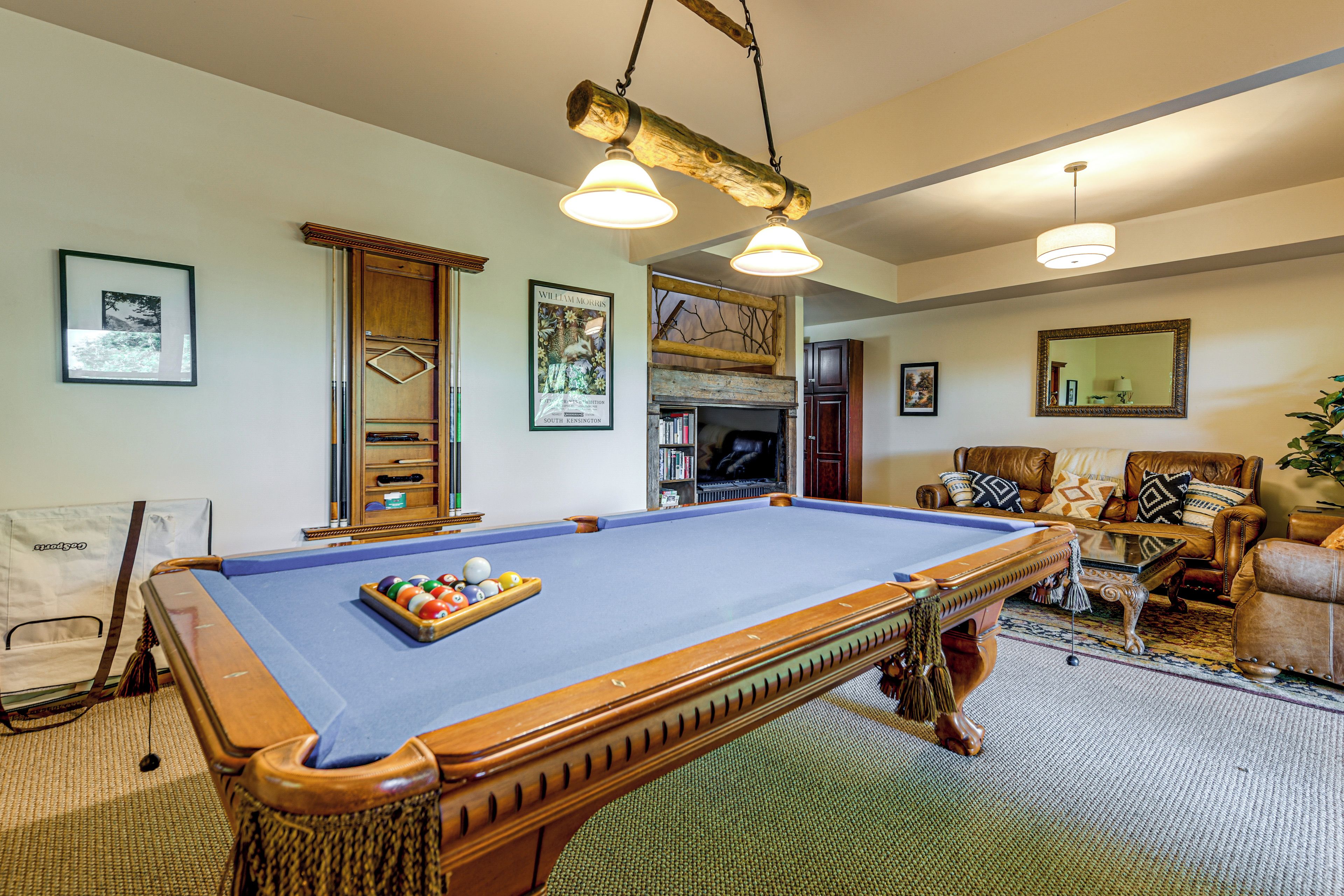 A pool table with balls, a billiard cue, and a pool table cover.