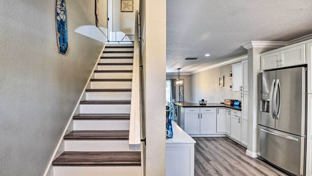 Una cocina moderna con armarios blancos, electrodomésticos de acero inoxidable y una escalera de madera.