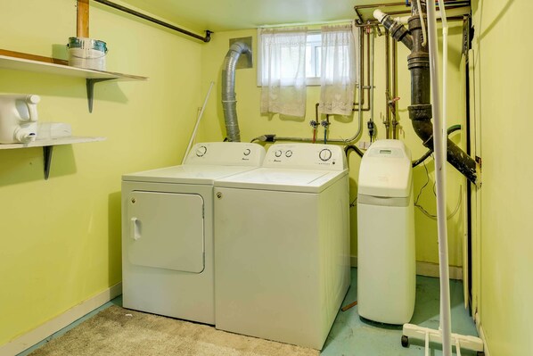 A laundry room with two washing machines, a dryer, and a water heater. - Spacious Wyoming Retreat: Fishing & Hunting (Torrington)