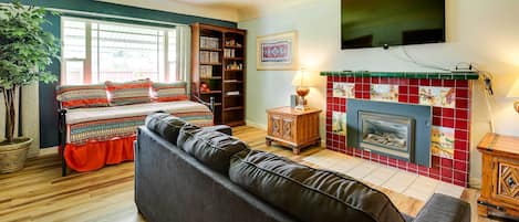 Hus (4 Bedrooms) | Vardagsrum | Tv, eldstad och böcker