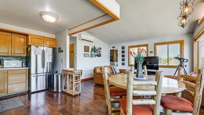 Une cuisine dotée de meubles en bois, d’un réfrigérateur en acier inoxydable et d’un coin repas avec une table et des chaises en bois.