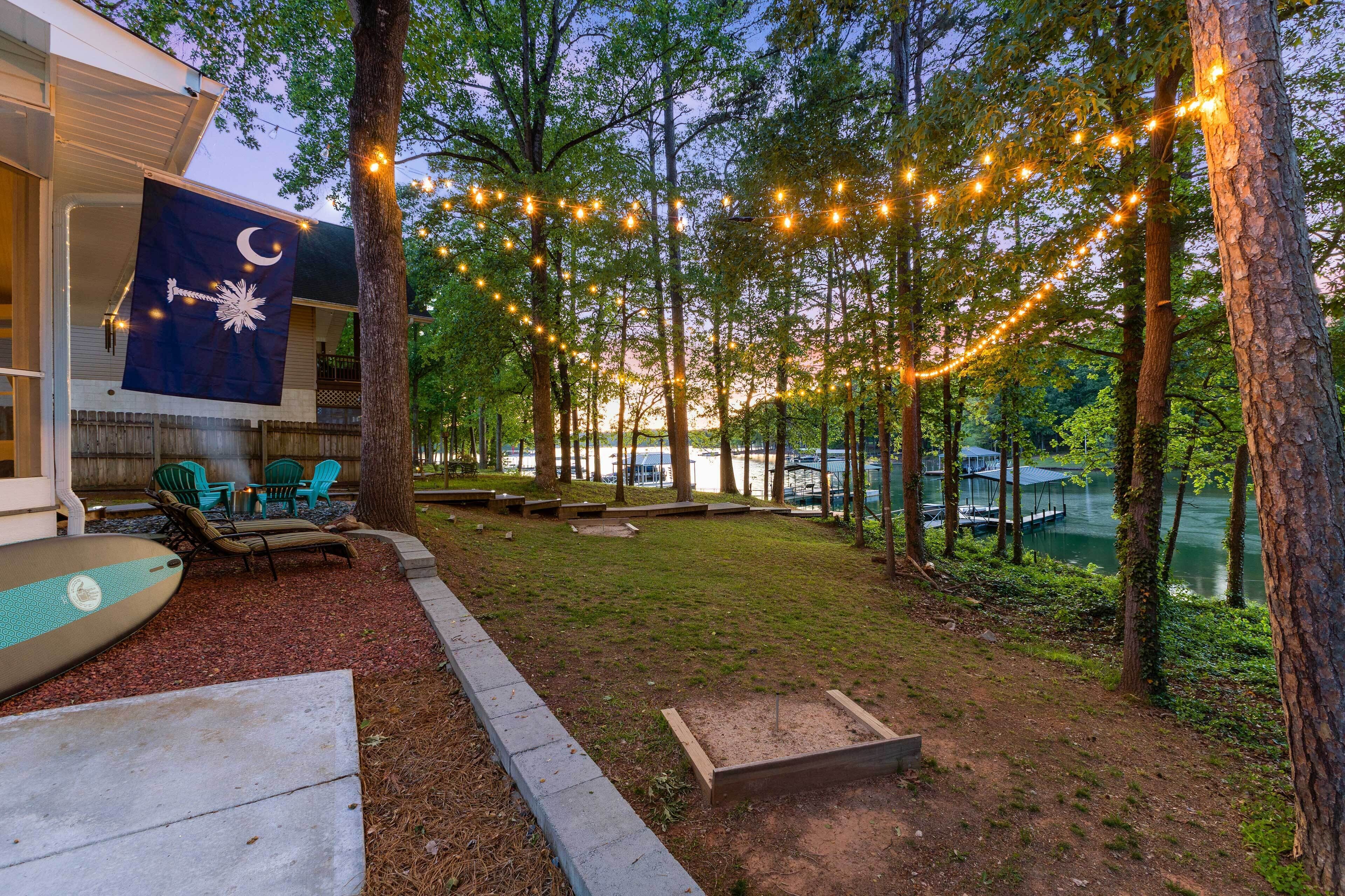 Patio con luces de cuerda, una bandera y muebles de exterior.