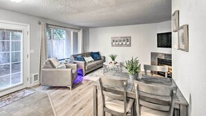 Een moderne woonkamer met een bank, salontafel en eettafel.