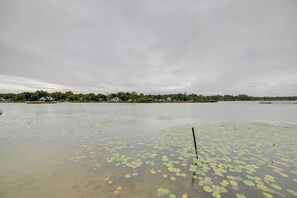 A lake with lily pads and a dock extending into the water.
