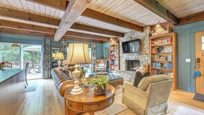 Una sala de estar acogedora con una chimenea de piedra, una amplia estantería y una zona de estar confortable.