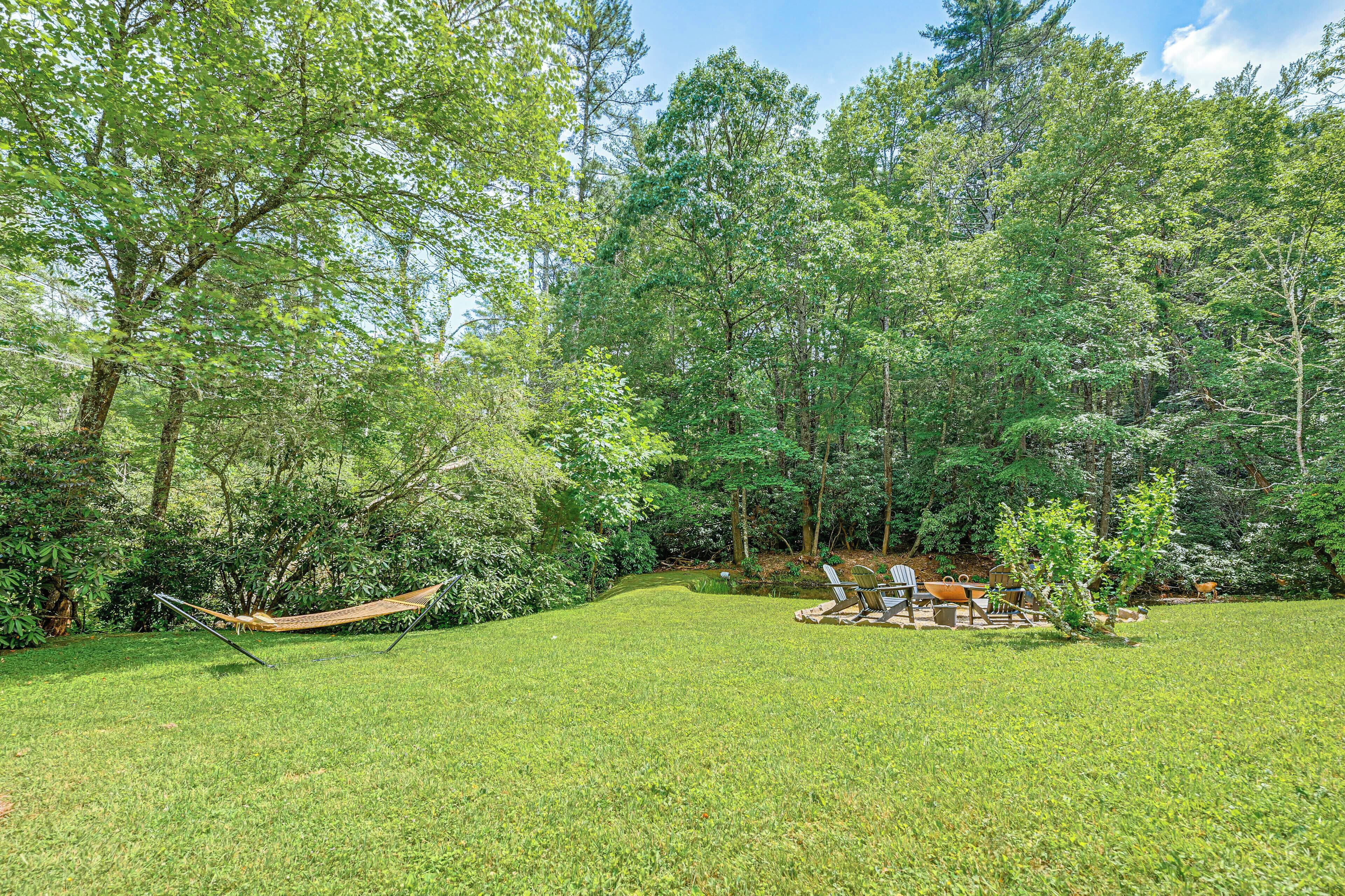 A grassy outdoor area with a hammock and outdoor furniture.
