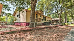A two-story house with a porch and a fenced yard. - Sues Camp w/ Caddo Lake Access & Dock! (Karnack)