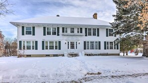 A two-story white house with green shutters, a central entrance, and a snow-covered yard. - 2nd-floor Dillon Apt - Near University & Fishing! (Dillon)
