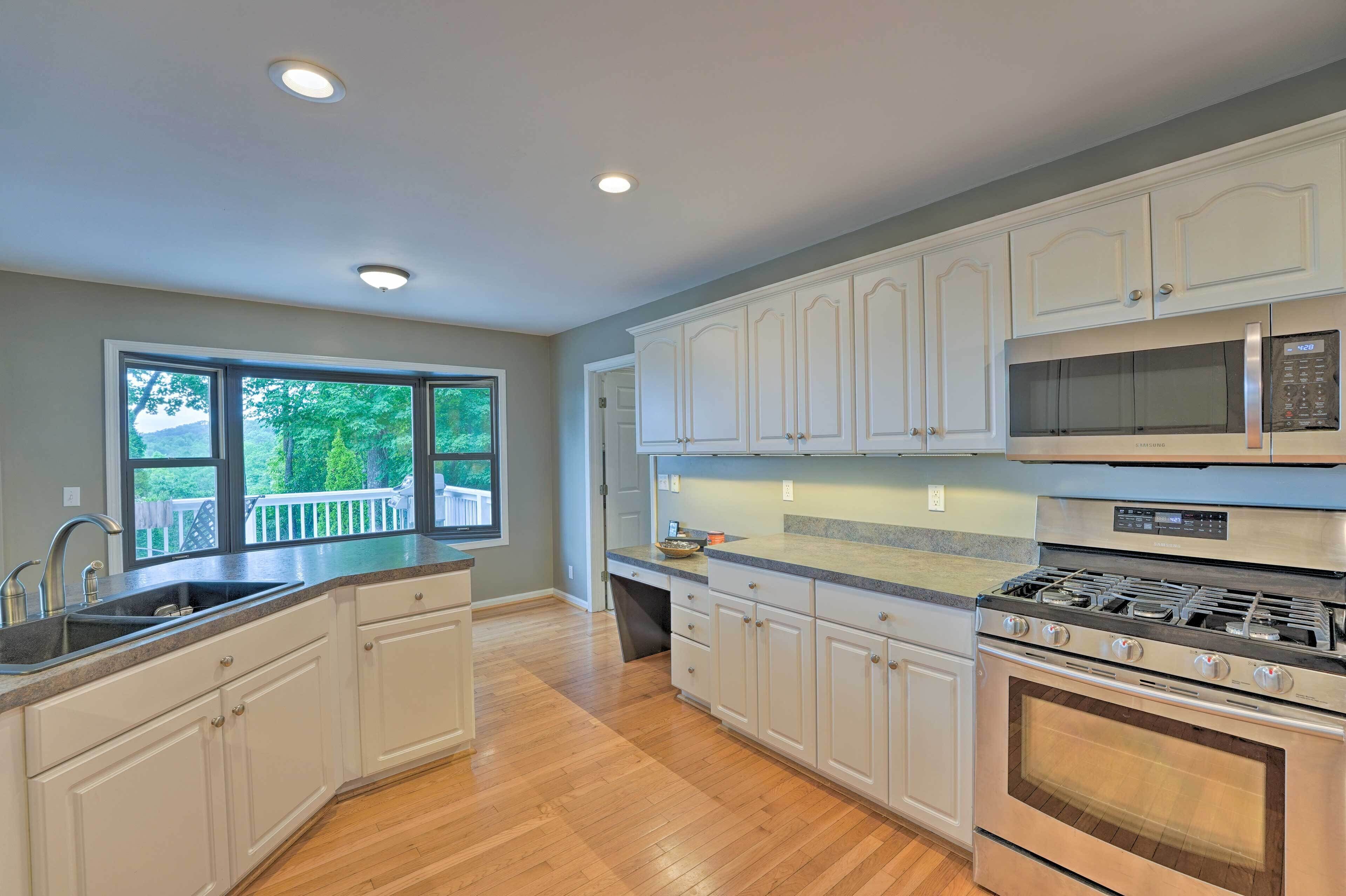 A kitchen with white cabinets, a stainless steel stove, and a microwave.