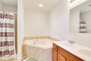 A bathroom with a bathtub, two sinks, a mirror, and a shower curtain. - Serene Pocono Escape: 4 Mi to Tobyhanna State Park (Tobyhanna)