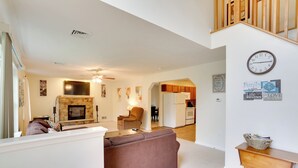 A spacious living room with a fireplace, a sofa, a dining area, and a kitchen in the background. - Serene Pocono Escape: 4 Mi to Tobyhanna State Park (Tobyhanna)