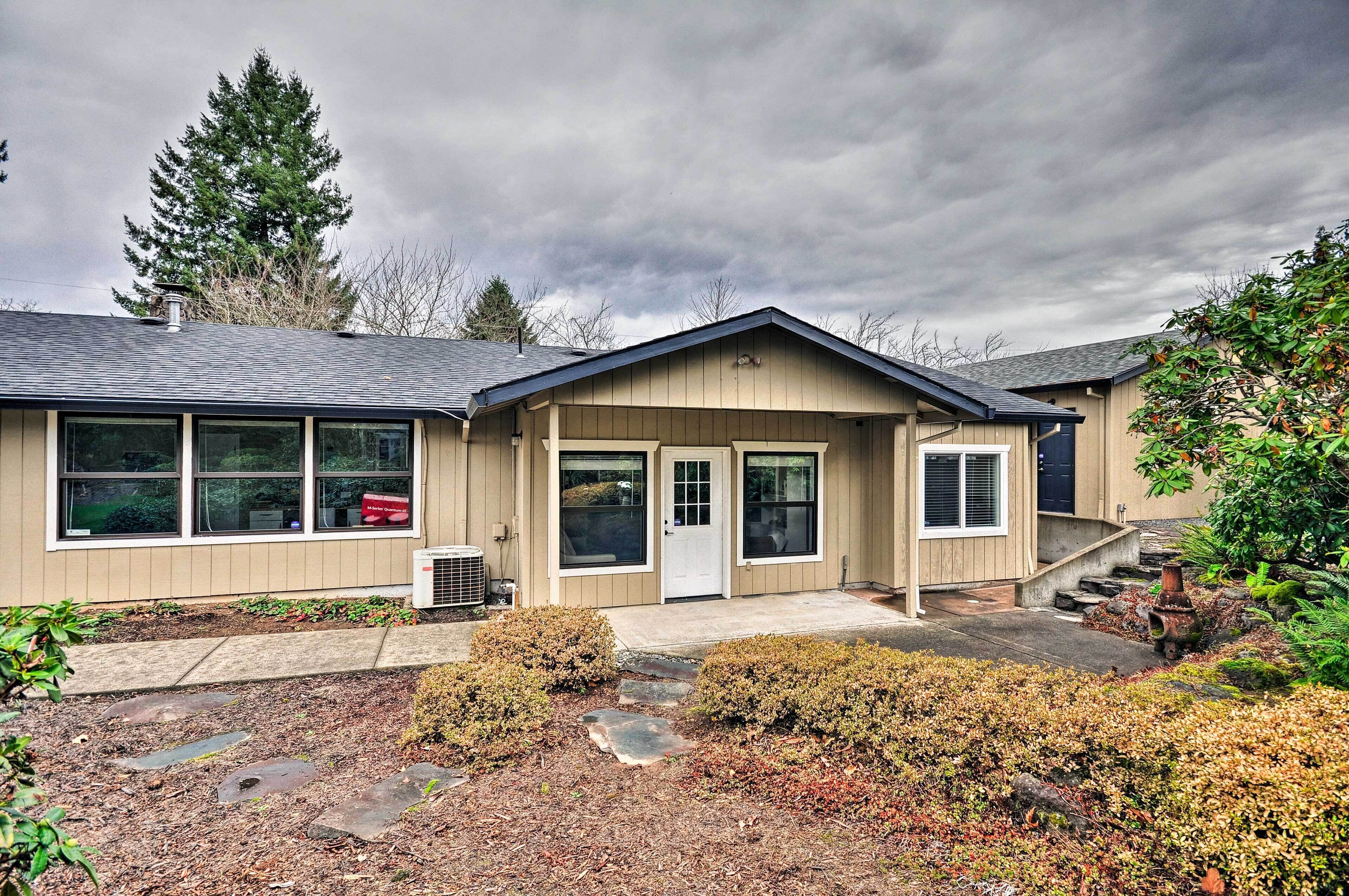 A single-story house with a front porch, a garage, and a small garden area with stepping stones.
