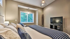 A bedroom with a bed, a TV, and a window with blinds. - Cute & Cozy PDX Area Townhouse: 31 Mi to Mt. Hood! (Boring)