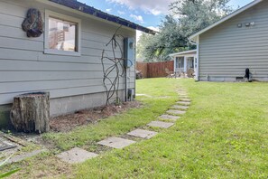 Il s’agit d’une propriété résidentielle dotée d’une pelouse bien entretenue, d’un chemin en pierre menant à la maison et d’une terrasse en bois.