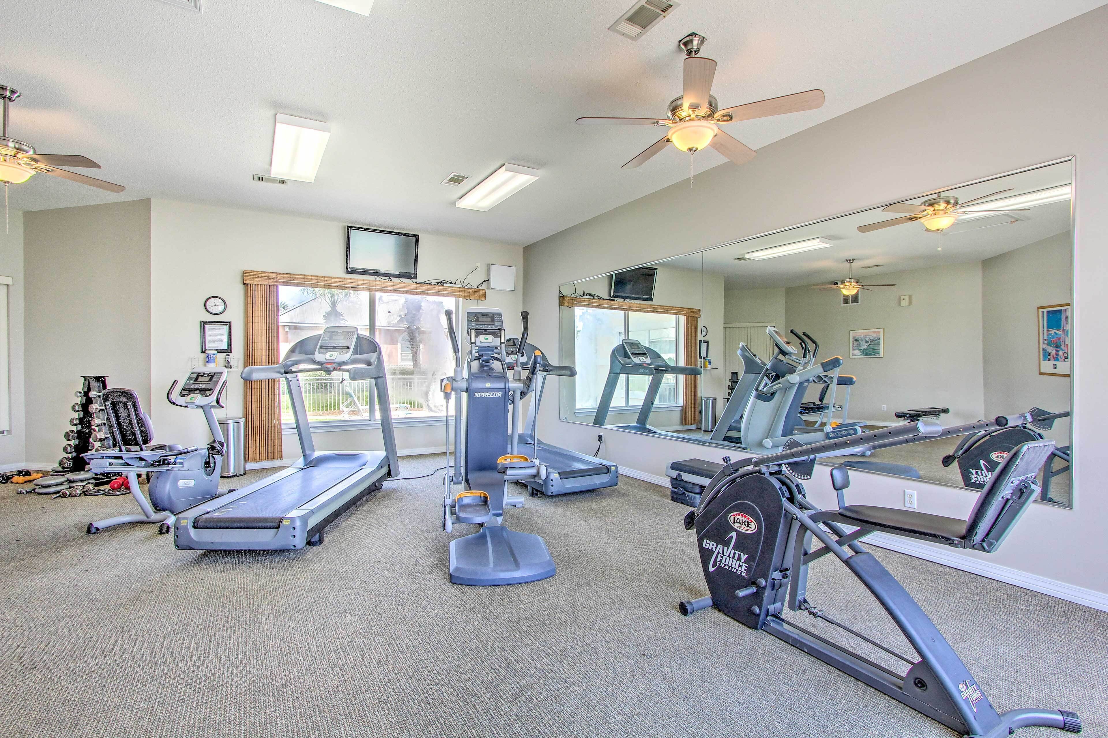 A gym with treadmills, elliptical machines, and a weight bench.