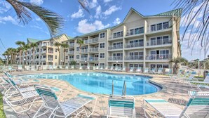 Um hotel com piscina, várias varandas e espreguiçadeiras.