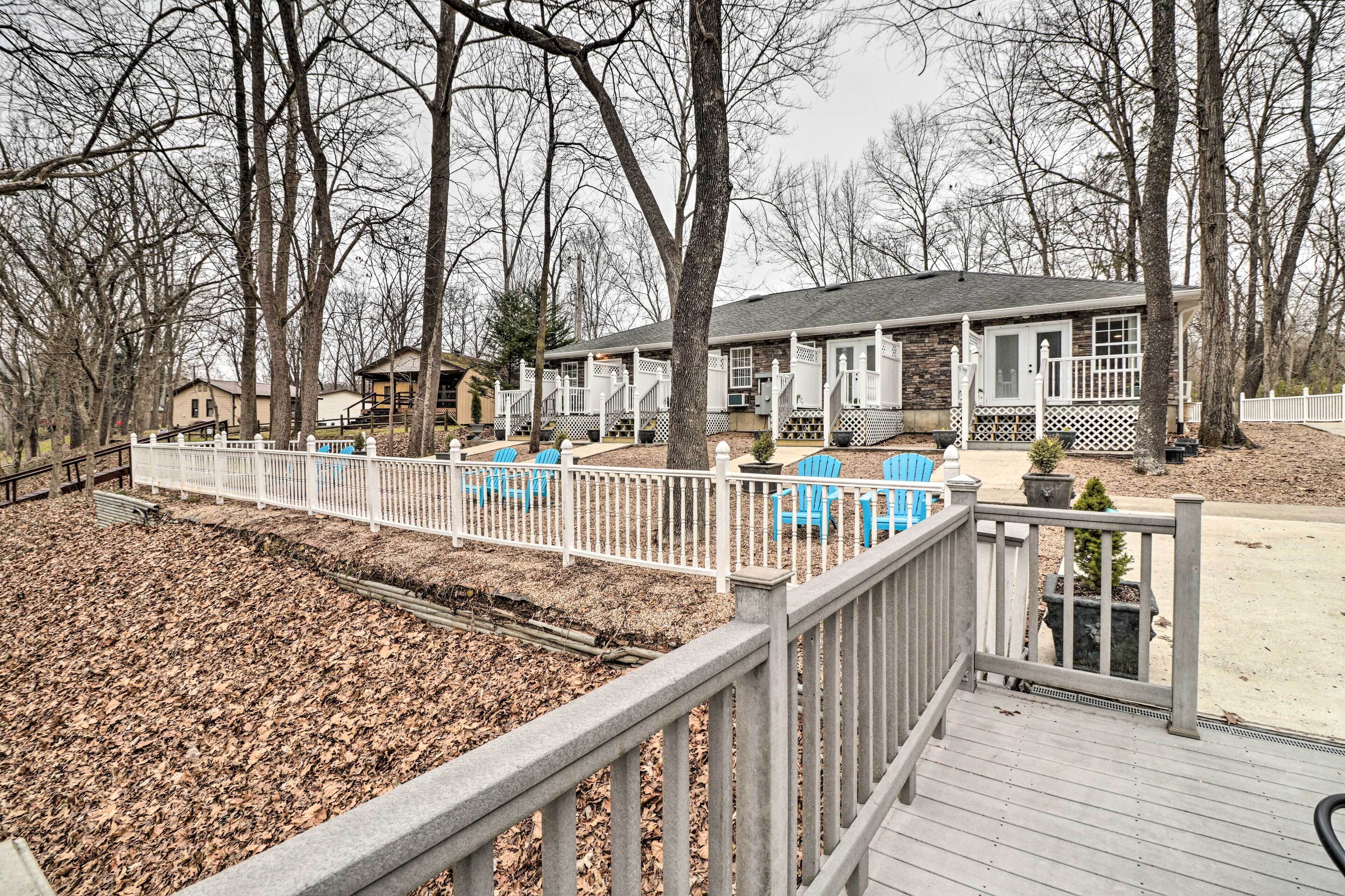 A residential property with a wooden deck, outdoor seating, and a fenced yard.