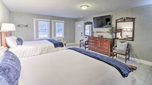 A bedroom with two beds, a dresser, a chair, a television, and a fish decoration on the wall. - Riverside Studio: Trophy Trout Fishing On-site (Lakeview)