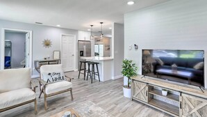 A modern living room with a sofa, TV, and a ceiling fan.