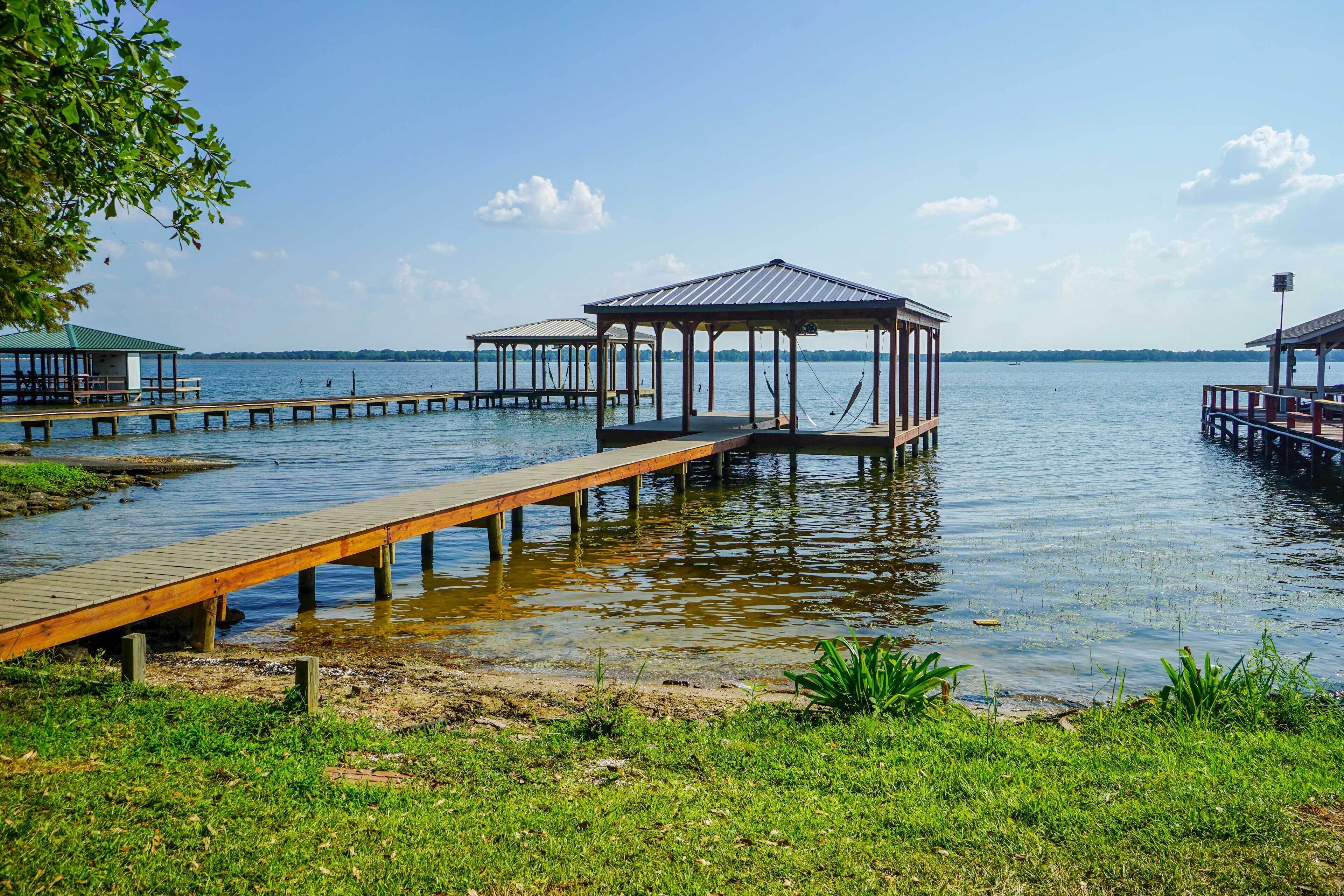 A waterfront property with wooden docks leading to covered structures.