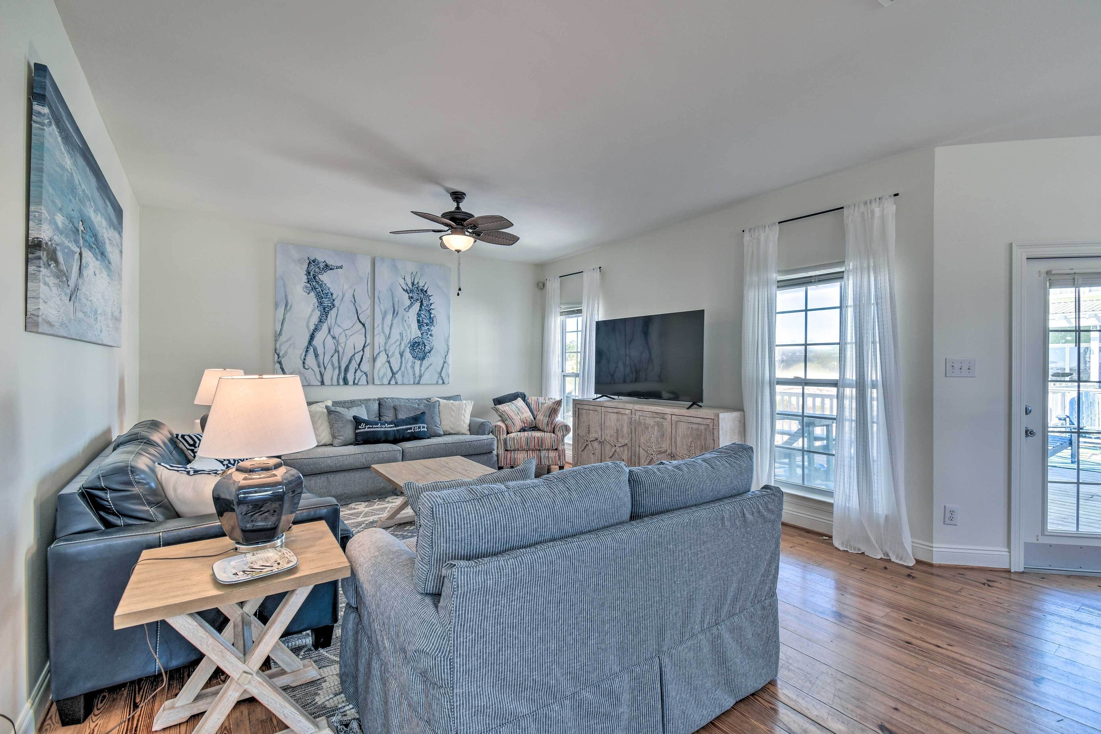 A modern living room with a sofa, a coffee table, a TV, and artwork on the walls.