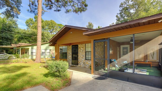 A two-story house with a stone facade, large windows, and a covered porch. - Ocala Home < 7 Mi to World Equestrian Center! (Ocala)