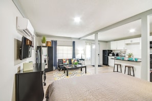Un appartement moderne comprenant un salon, une cuisine et un coin repas. Il est équipé d’un canapé, d’une table basse et d’un téléviseur.