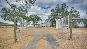 A gated entrance to a property with a gravel path leading to a house. - Mariposa Home: Furnished Patio & Sierra Mtn Views (Mariposa)