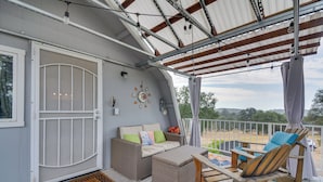 A covered outdoor area with wicker furniture, a door with a screen, and a view of the outdoors. - Mariposa Home: Furnished Patio & Sierra Mtn Views (Mariposa)