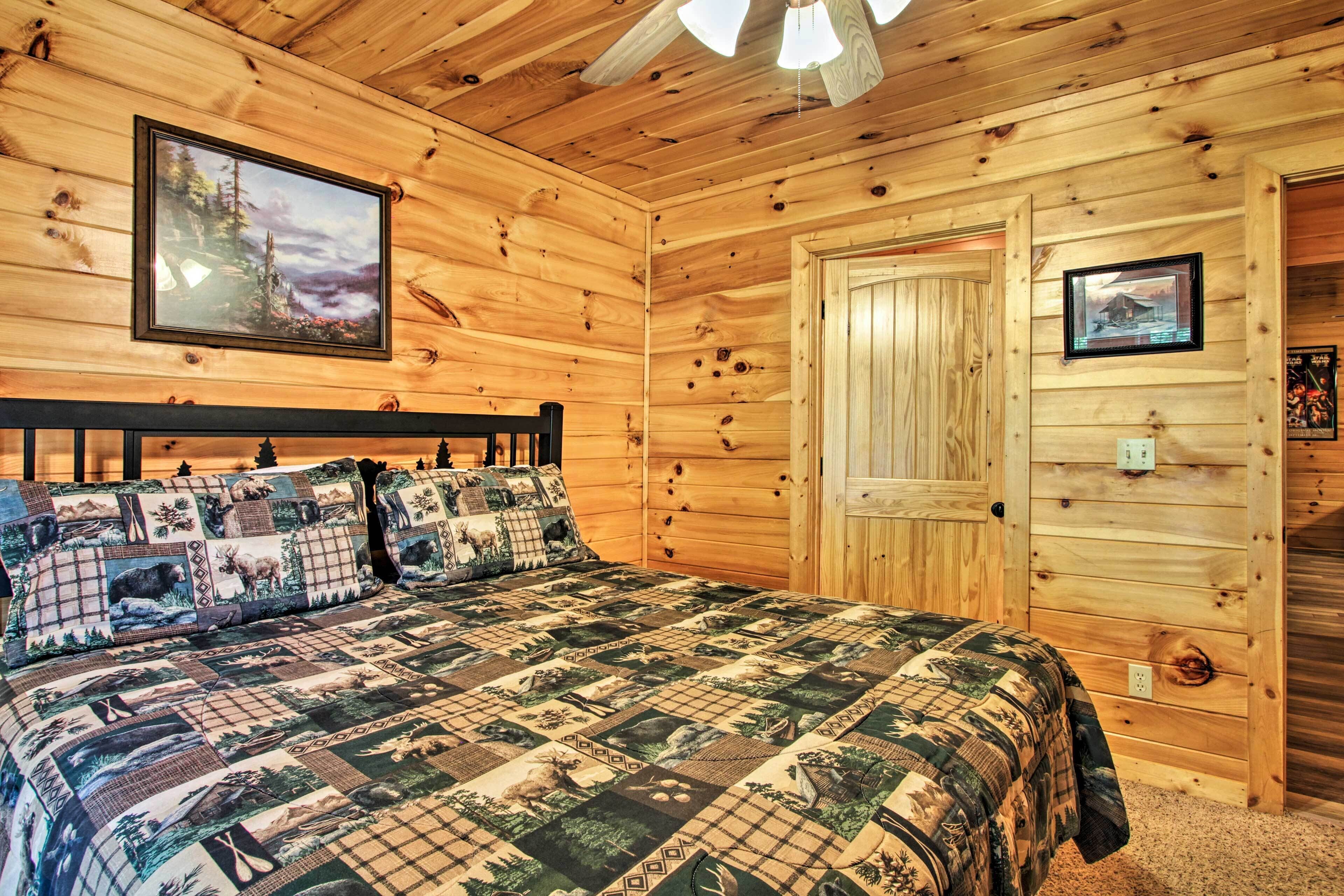 Ein Schlafzimmer einer Holzhütte mit einem Bett, einem Nachttisch und einer Tür.