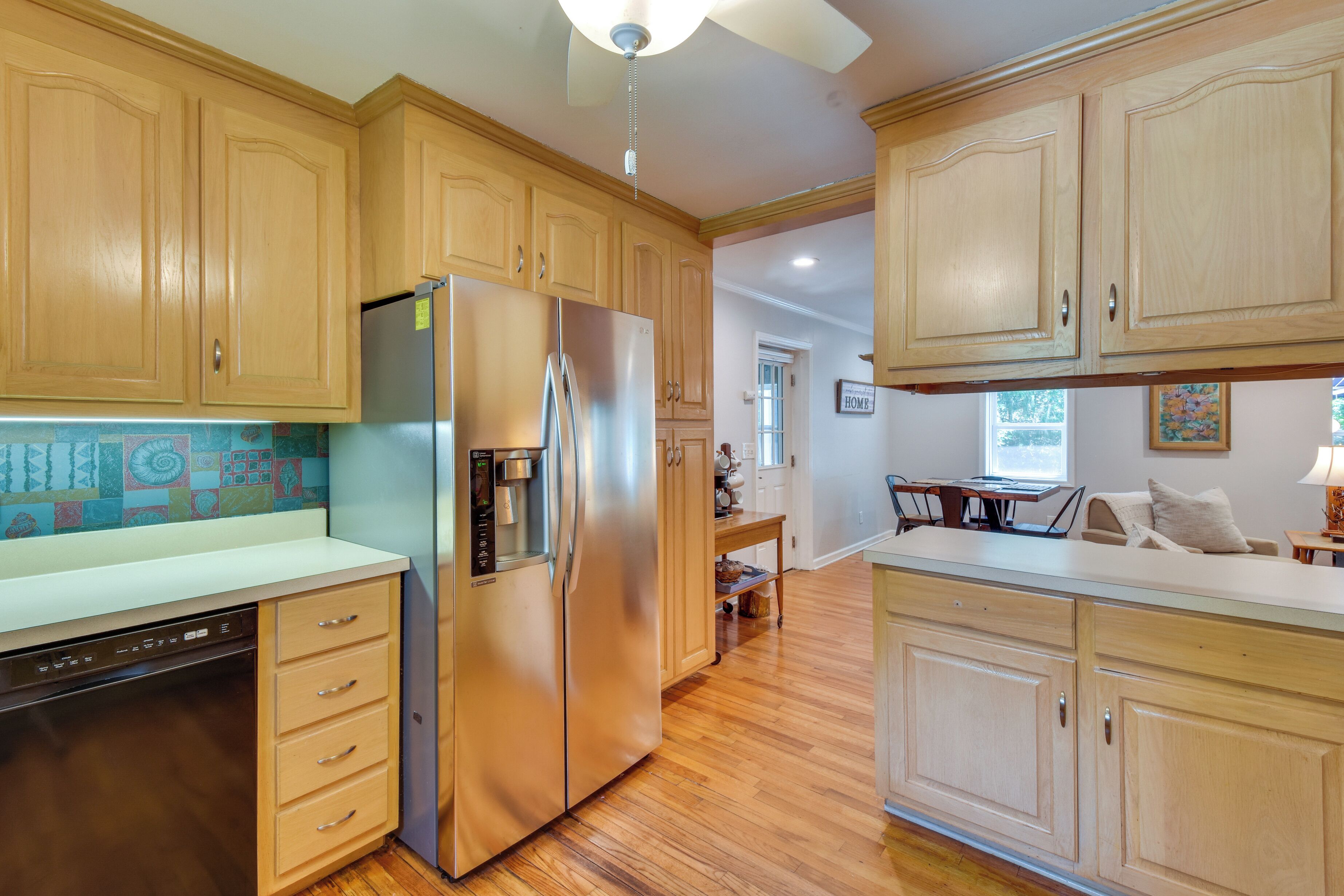 A kitchen with wooden cabinets, a stainless steel refrigerator, and a dishwasher.