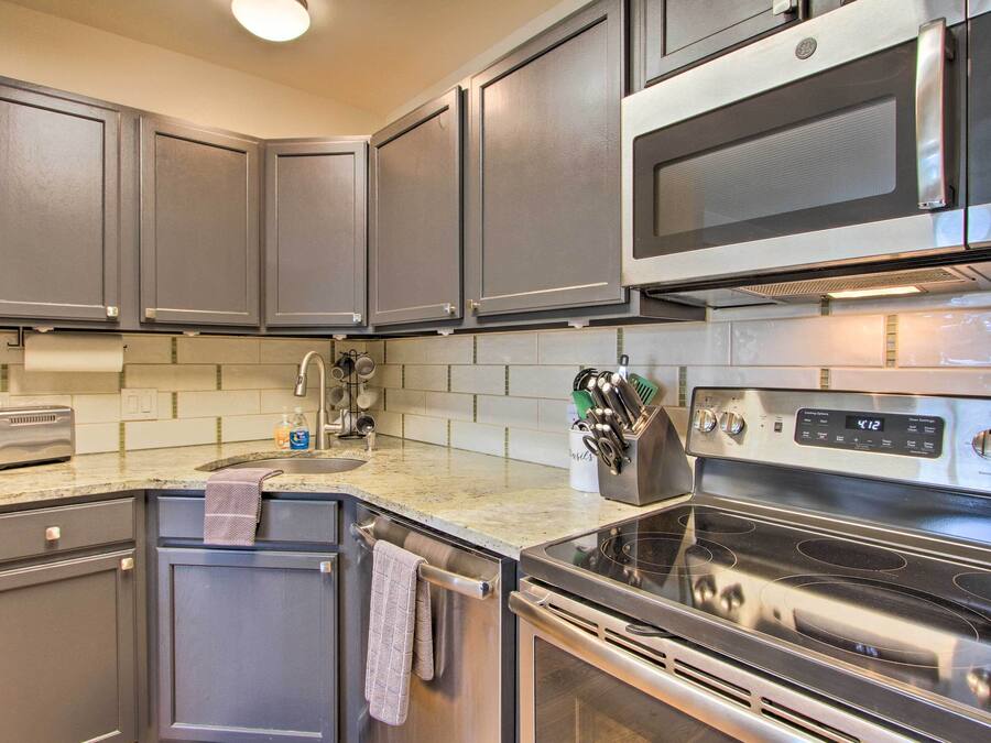 A modern kitchen with stainless steel appliances, including a microwave, oven, and toaster.