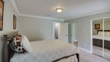 A bedroom with a bed, a door, and a mirror.