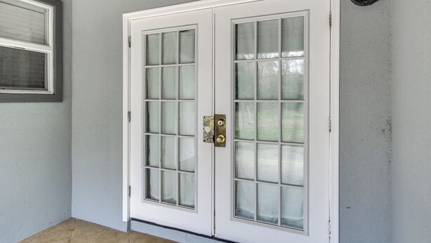 A white door with glass panels and a brass handle. - Gulfport Condo w/ Private Balcony - Walk to Beach! (Gulfport)