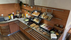 A buffet setup with various food items, including fruits, pastries, and condiments. - Flag Hotel Lisboa Oeiras (Oeiras)