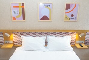A hotel room with a bed, two bedside tables with lamps, and three motivational posters on the wall. - Flag Hotel Lisboa Oeiras (Oeiras)